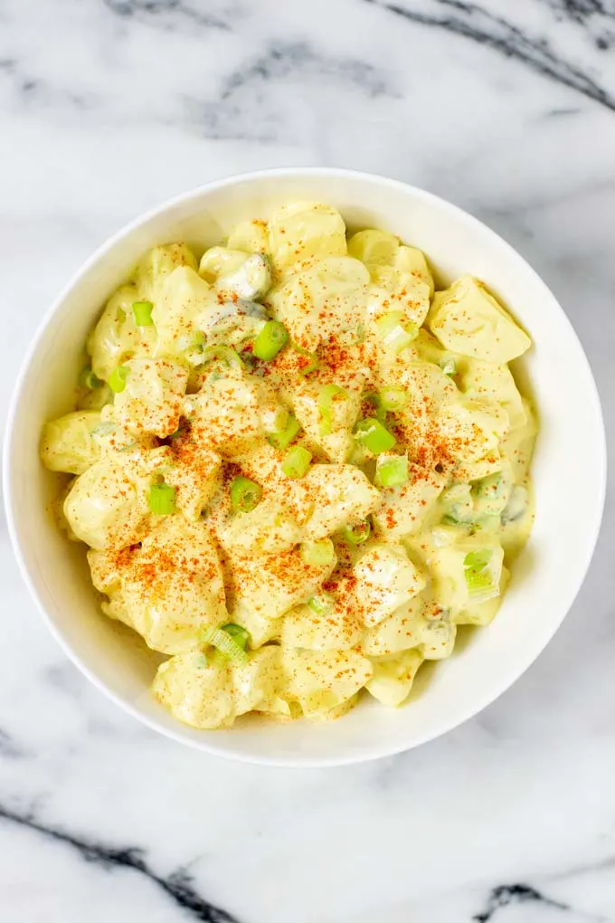 Top view of a serving bowl with the Southern Potato Salad, garnished with extra paprika powder.