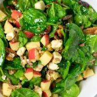 Closeup on the Spinach Salad in a white serving bowl.