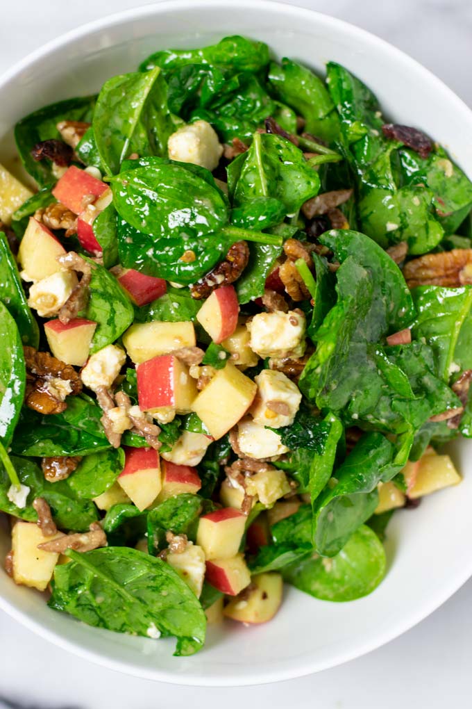 Closeup on the Spinach Salad in a white serving bowl.