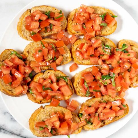 Top view of a large white plate with Bruschetta.