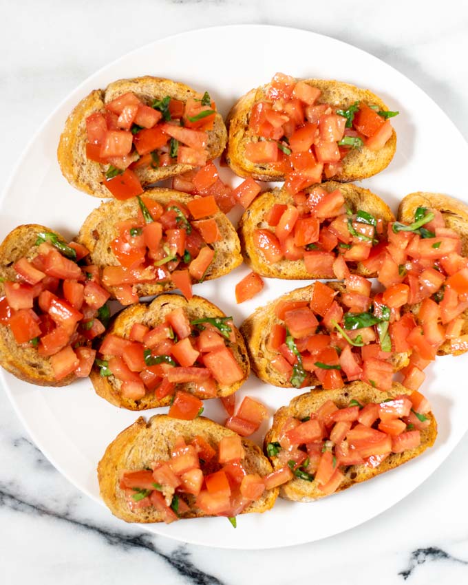 Top view of a large white plate with Bruschetta.