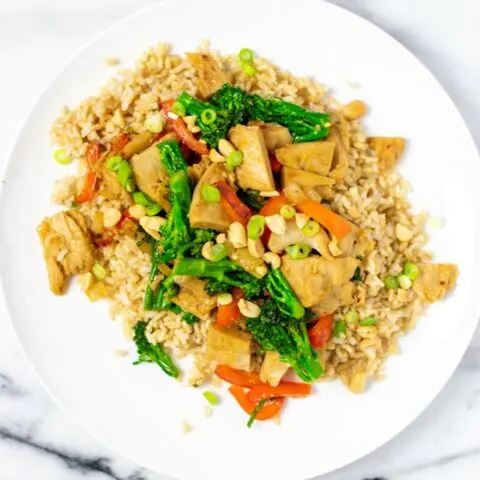 Chicken Stir Fry is served with scallions and peanuts over rice.