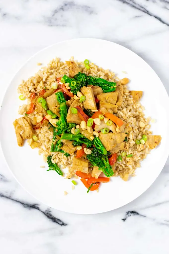 Chicken Stir Fry is served with scallions and peanuts over rice.