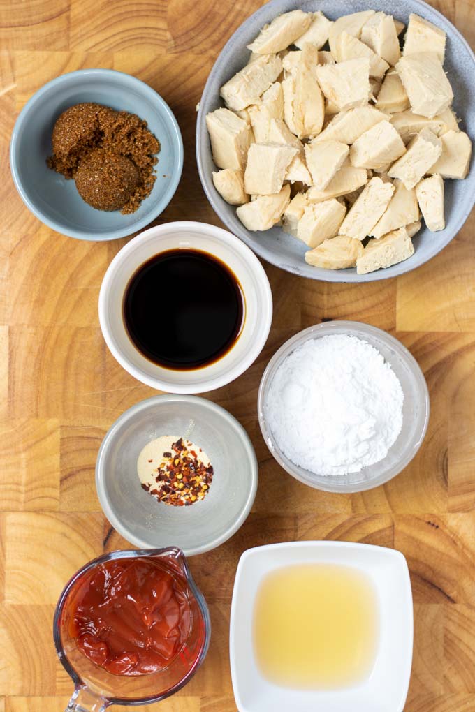 Ingredients needed for making the Sweet and Sour Chicken are collected on a wooden board.
