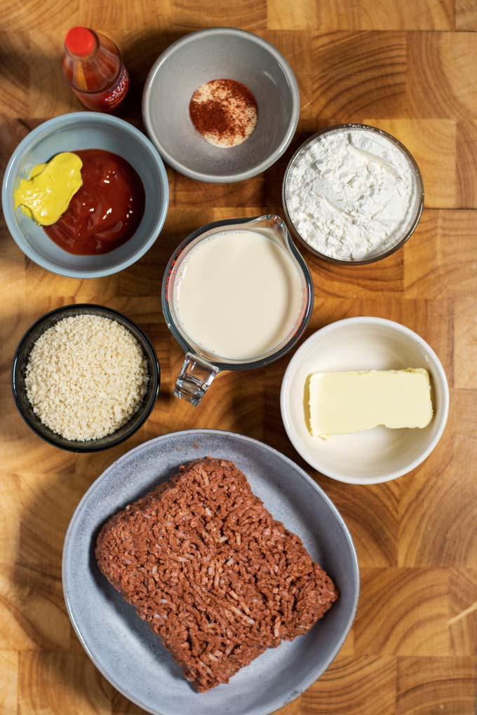 Ingredients for the Country Fried Steak are collected on a wooden board.