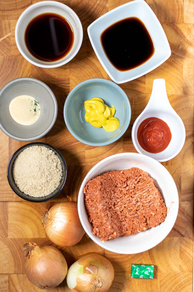 Ingredients needed to make Hamburger Steaks are assembled on a wooden board.