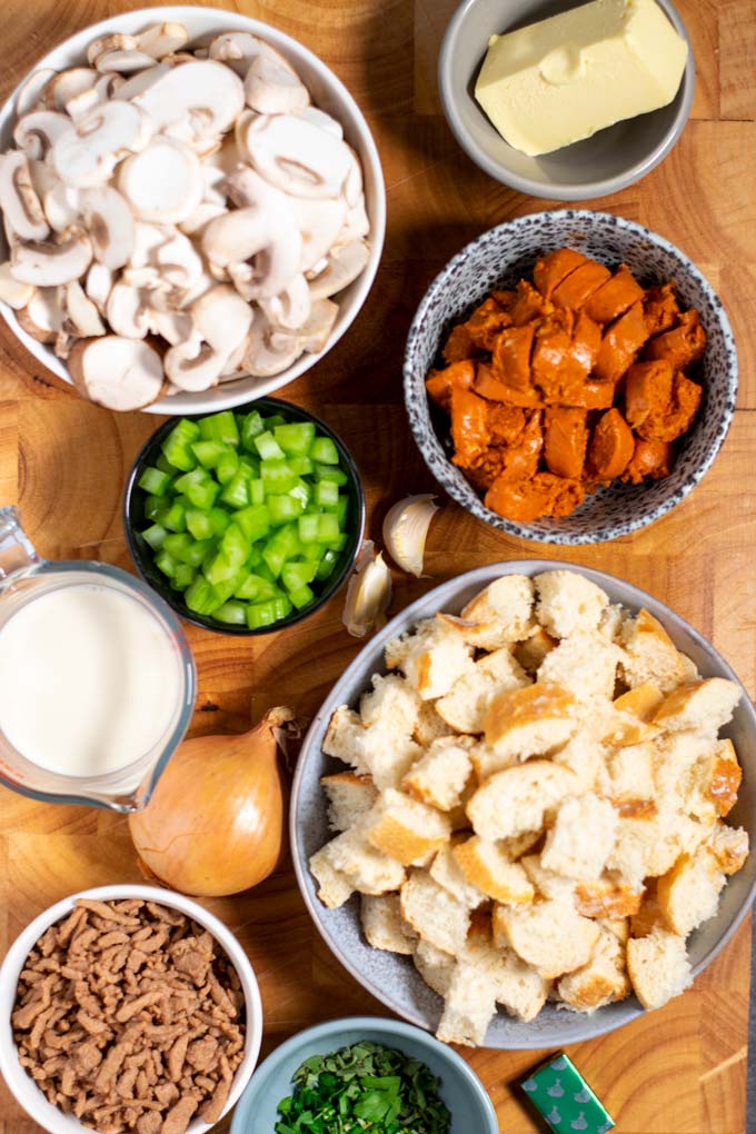 Ingredients needed to make Mushroom Stuffing are collected on a wooden board,