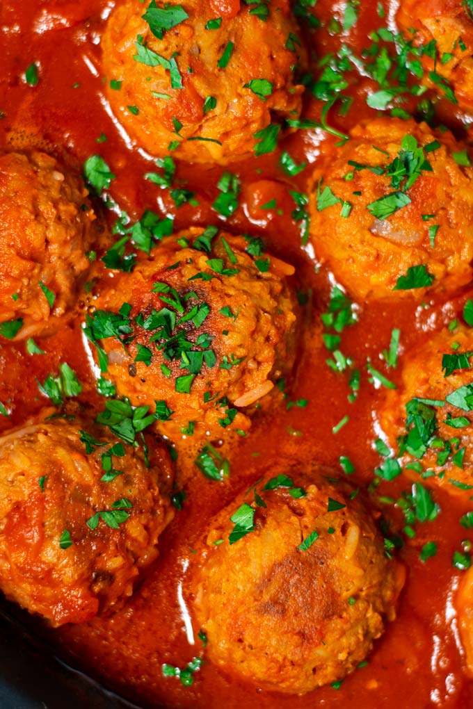 Zooming in to the meatballs in sauce, showing the rice grains in them.