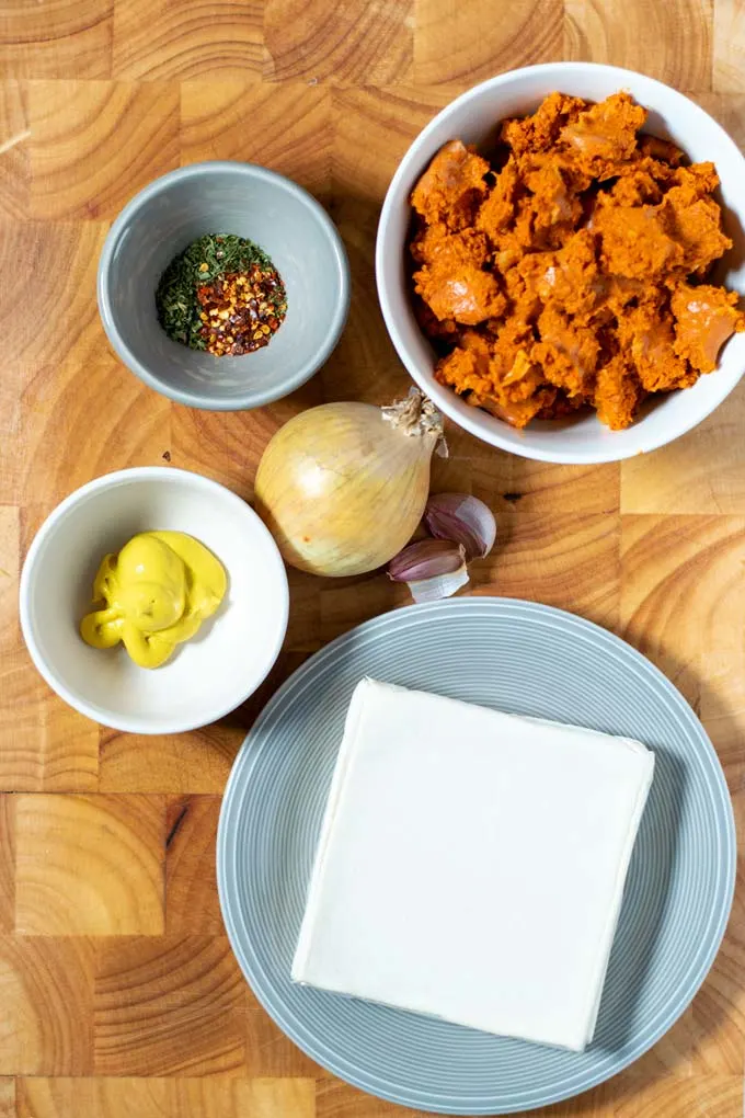 Ingredients needed for making Sausage Rolls are assembled on a wooden board.