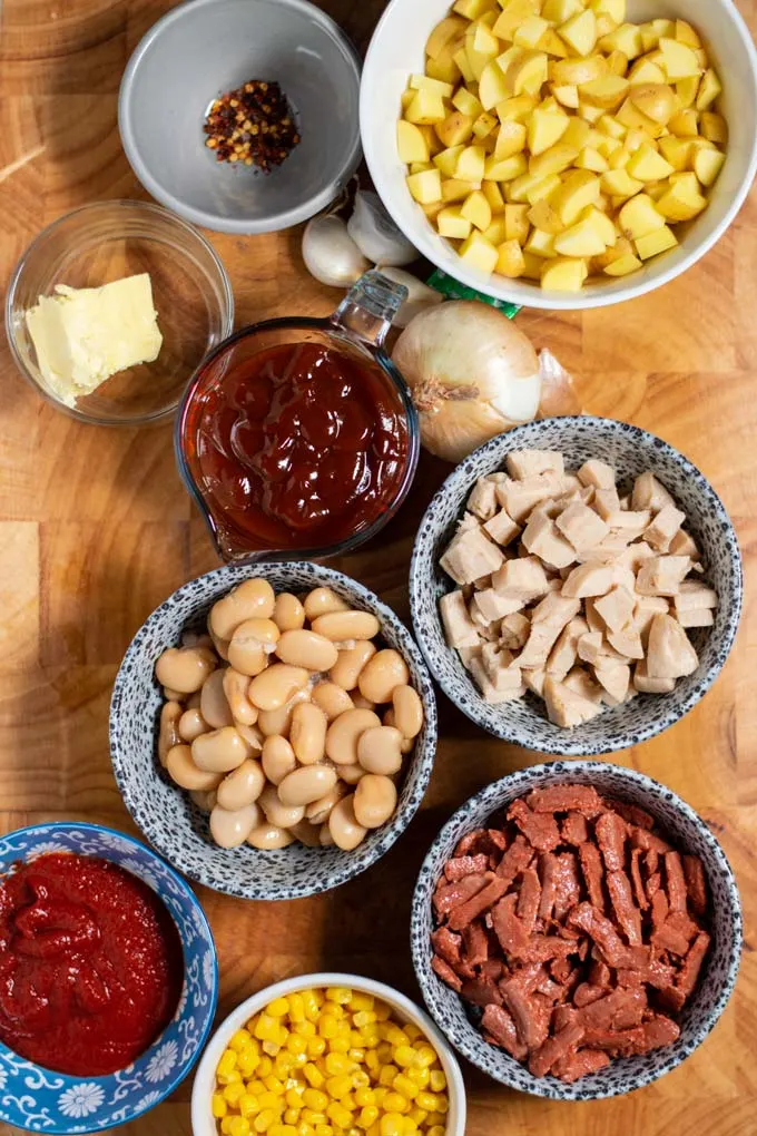 Ingredients needed to make Brunswick Stew are assembled on a wooden board.