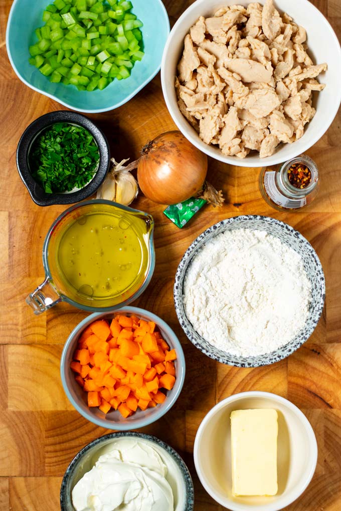 Ingredients for Chicken and Dumplings are assembled on a wooden board.