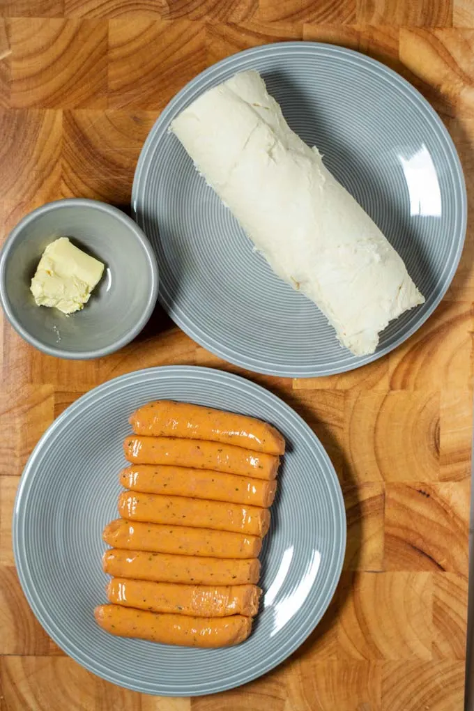 Ingredients needed for making Pigs in a Blanket are collected on a board.