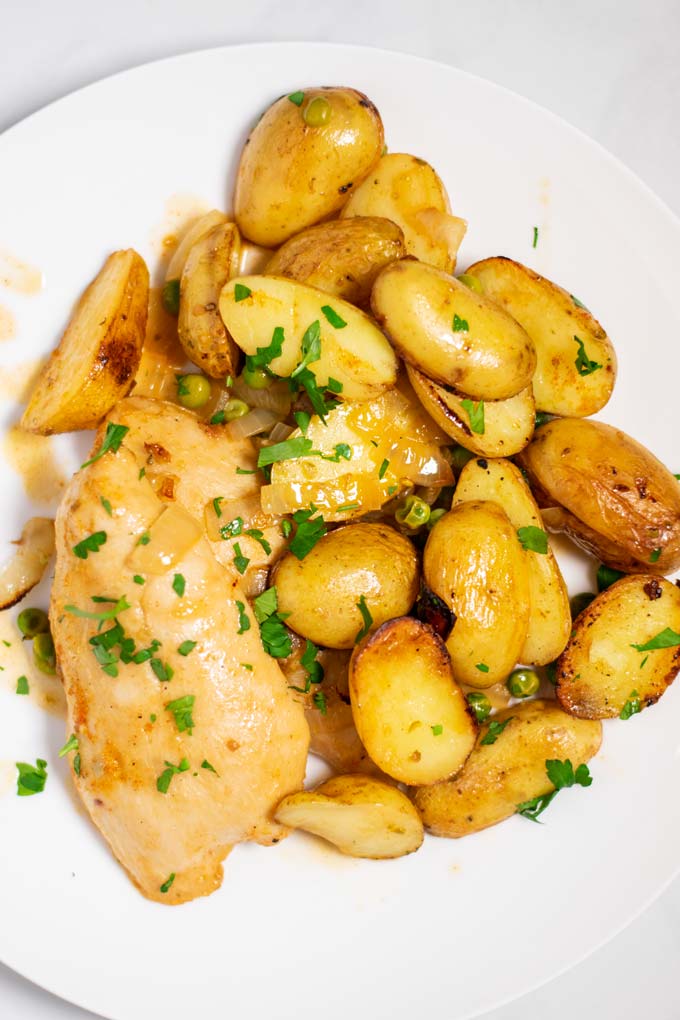 Top view of a portion of Chicken Vesuvio, served in a white plate.