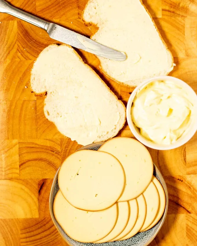 First step in making Grilled Cheese Sandwich is spreading metal on the bread slices.