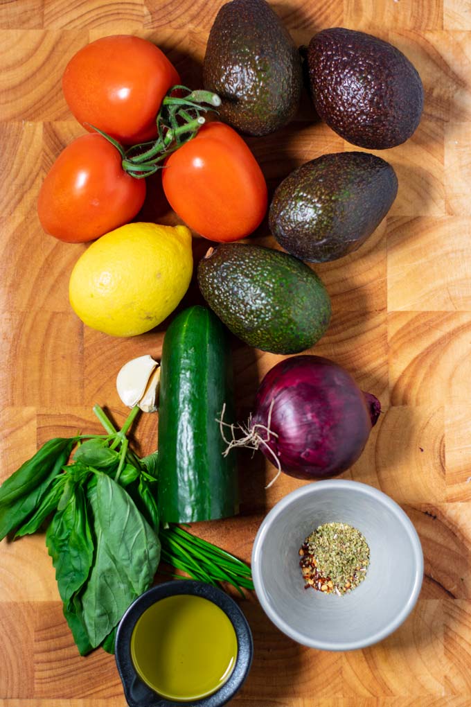 Ingredients needed to make Avocado Salad are assembled on a board.