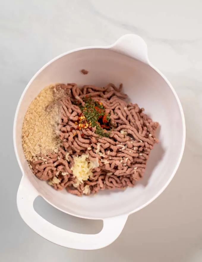 Top view on a large mixing bowl with the ingredients for Sausage Patties.