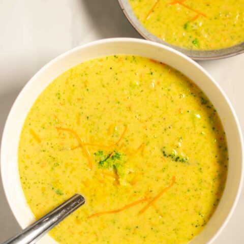 Portions of Broccoli Cheddar Soup are served in white bowls.