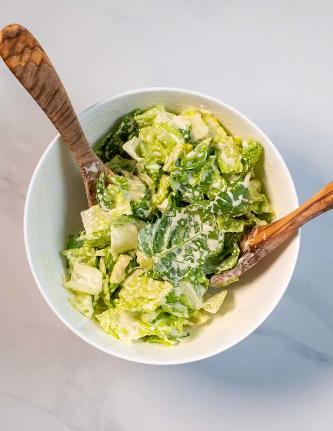 A salad is dressed with Caesar Dressing.