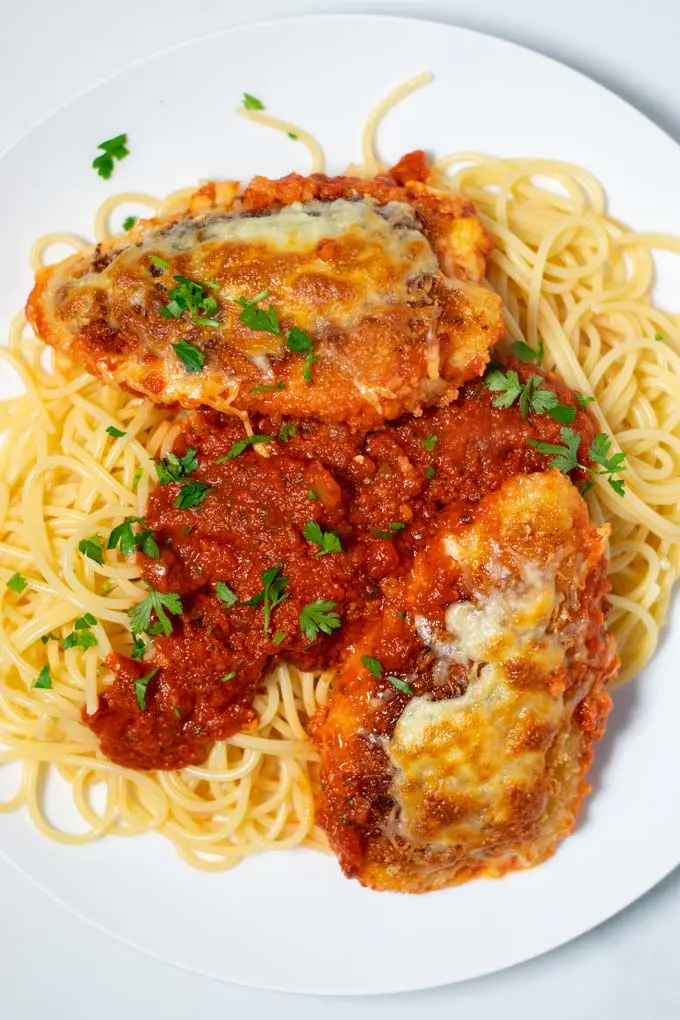 A portion of Chicken Parmesan is served with pasta.
