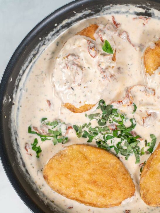 Sauce is given over Marry Me Chicken in a pan.