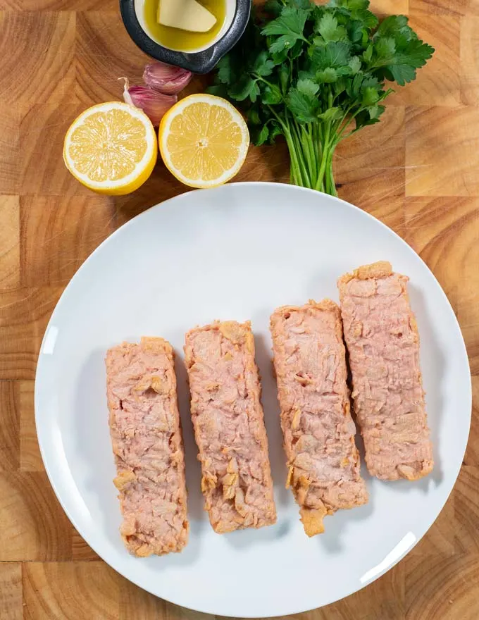 Ingredients needed to make Pan Seared Salmon are collected on a board.