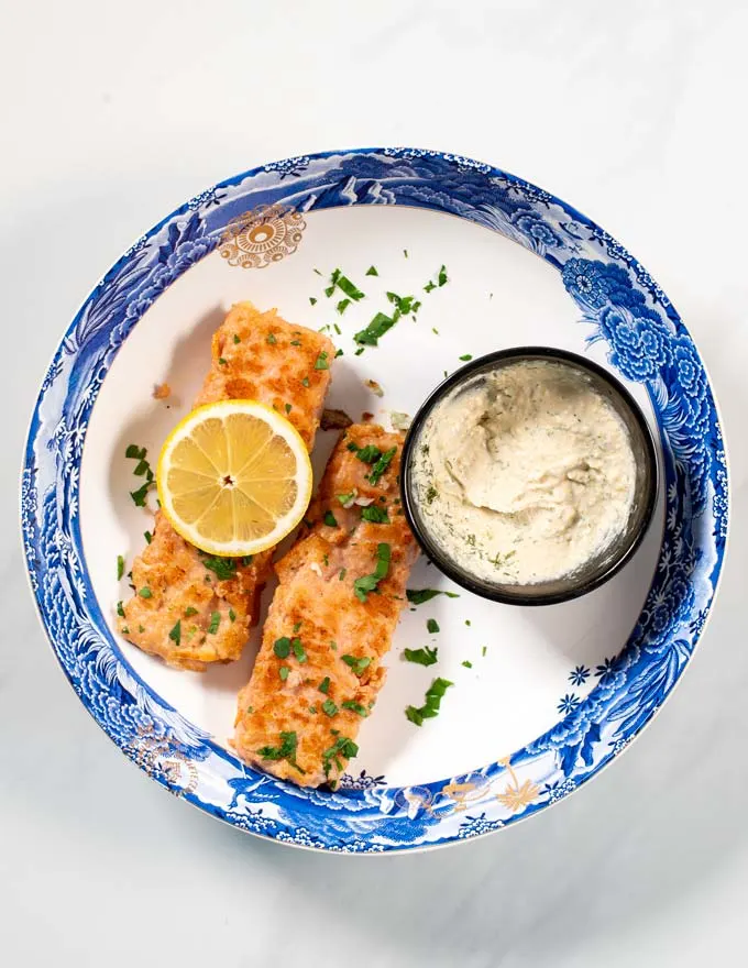 A portion of Pan Seared Salmon with dipping sauce.