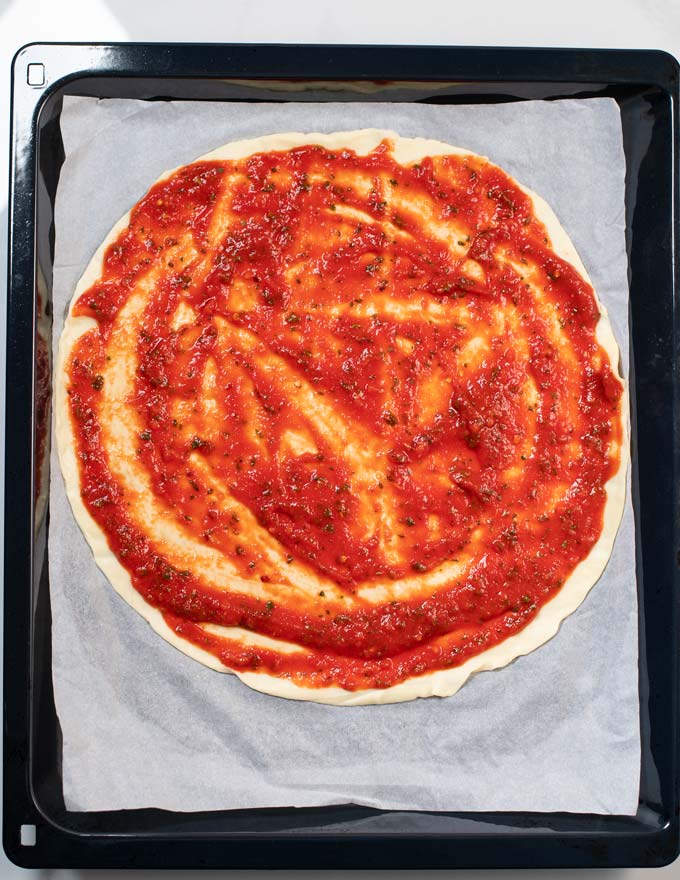 A homemade pizza is covered in Pizza Sauce.
