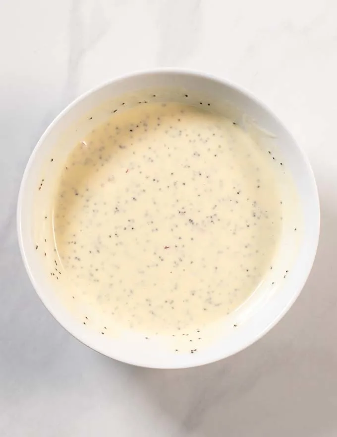 Top view of a mixing bowl with the mixed Poppy Seed Dressing.