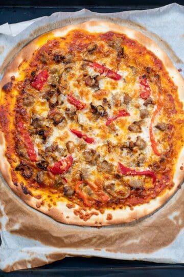 Top view of the ready Sausage Pizza coming out of the oven.