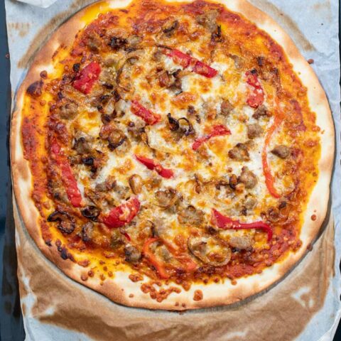 Top view of the ready Sausage Pizza coming out of the oven.