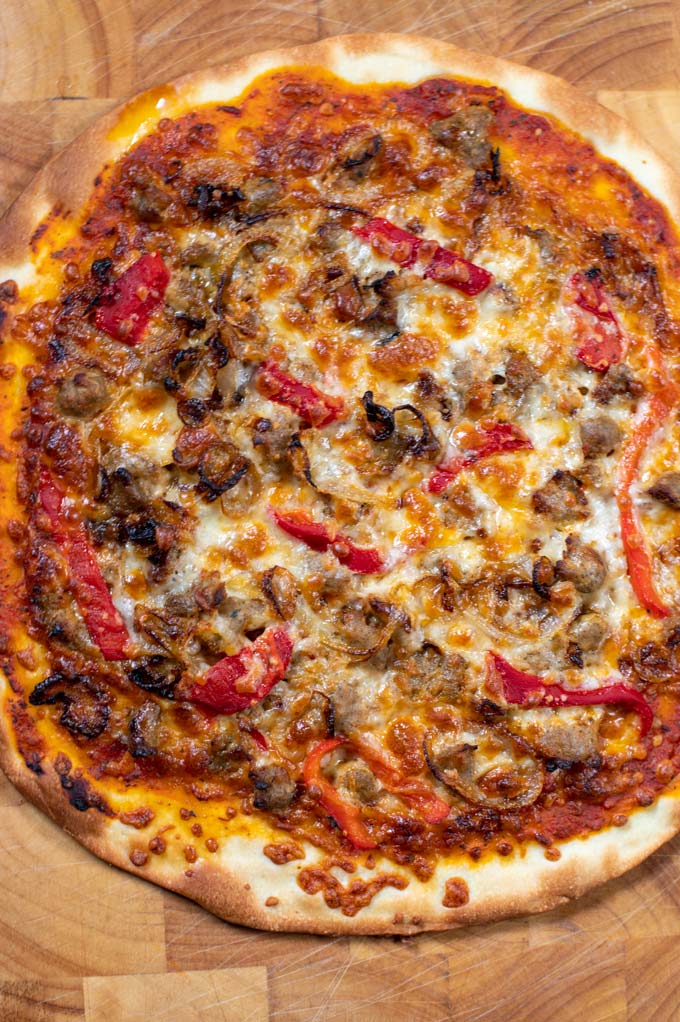 Closeup of the Sausage Pizza on a wood board.