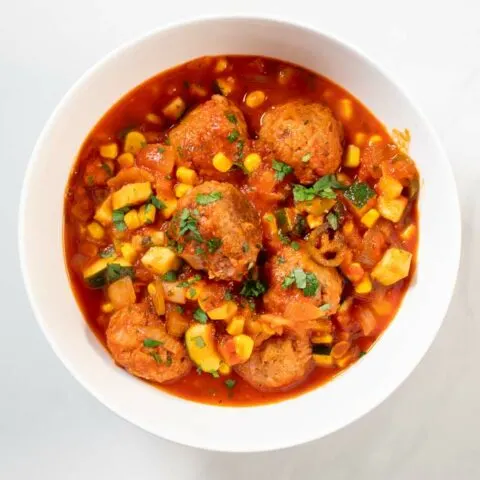 A portion of Albondigas Soup served in a white serving bowl.