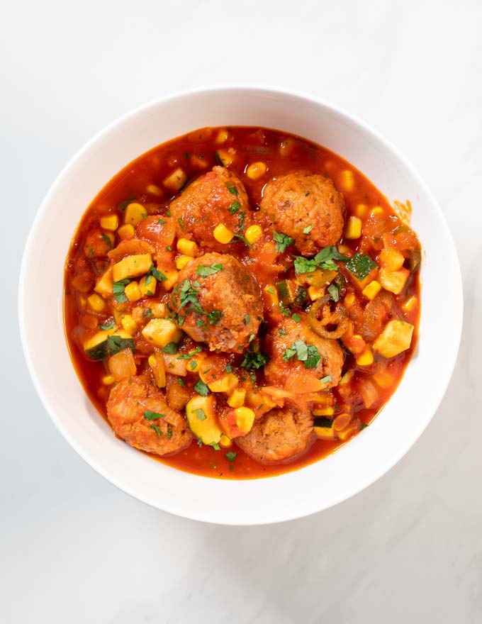 A portion of Albondigas Soup served in a white serving bowl.