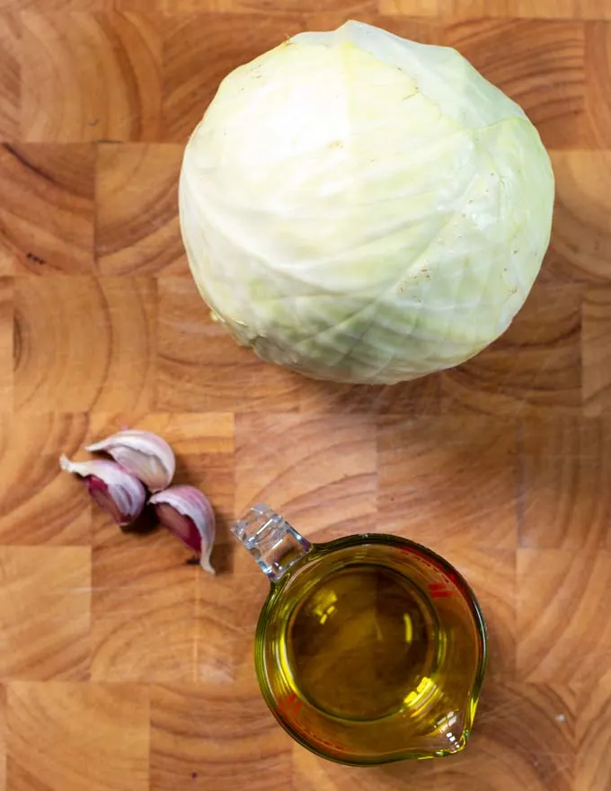 Ingredients needed to make cabbage Steak collected on a board.