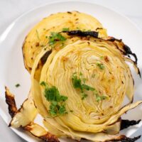 Closeup on Cabbage Steaks, garnished with fresh herbs.