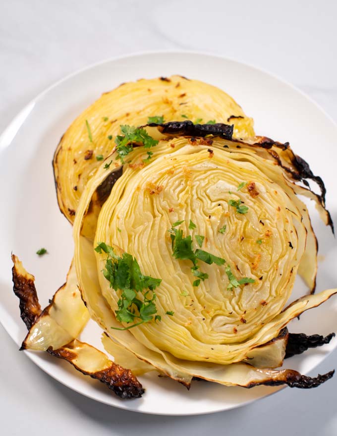 Closeup on Cabbage Steaks, garnished with fresh herbs.