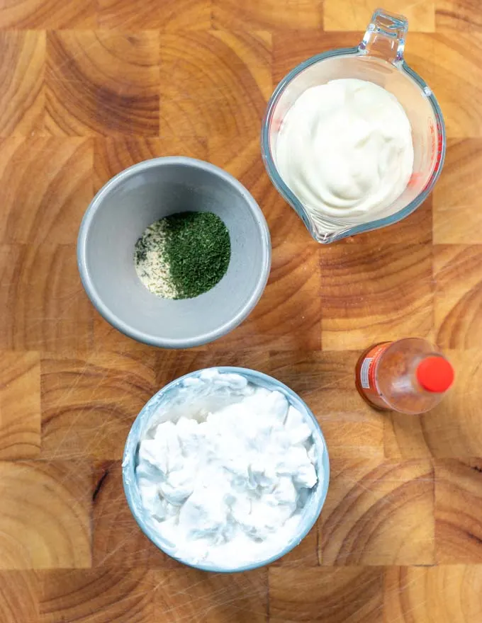 Ingredients needed for making Dill Dip are collected on a board.