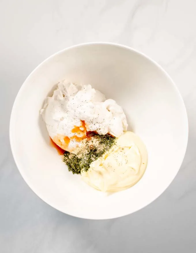 Top view on a large mixing bowl with the ingredients for Dill Dip.