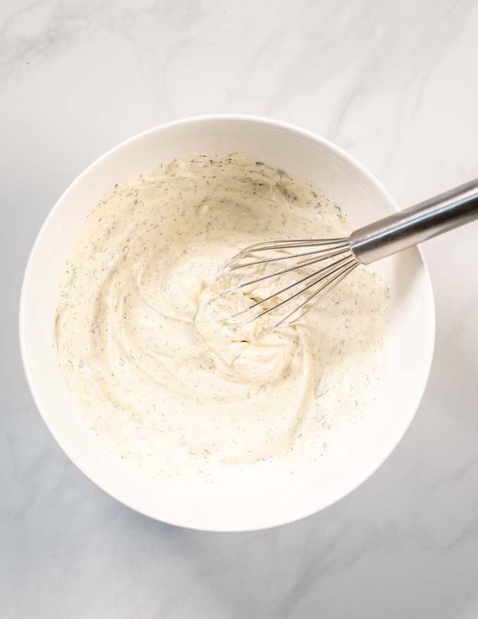 Step by step picture showing how Dill Dip is whipped together in a large white bowl.