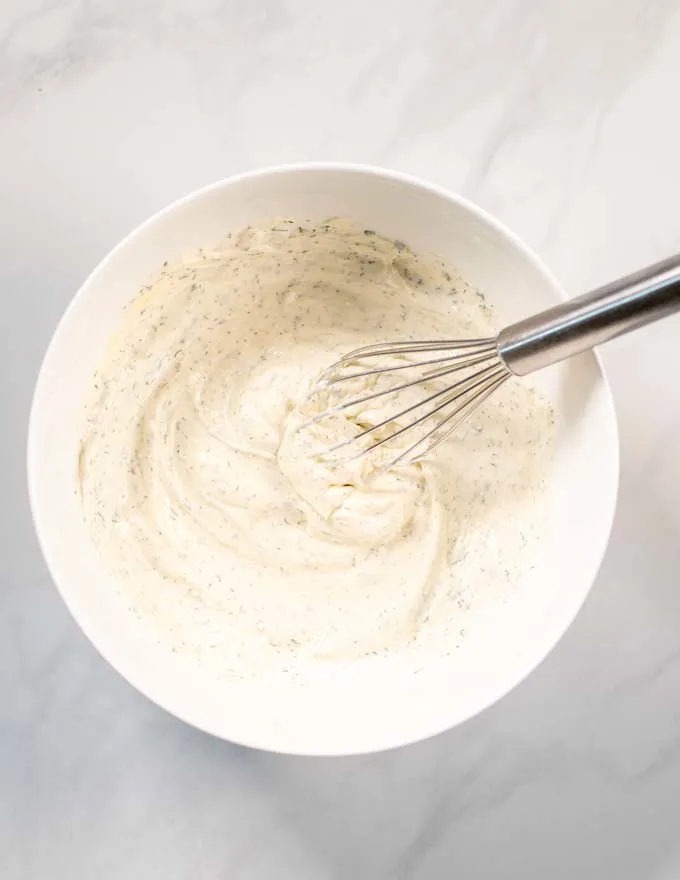 Step by step picture showing how Dill Dip is whipped together in a large white bowl.