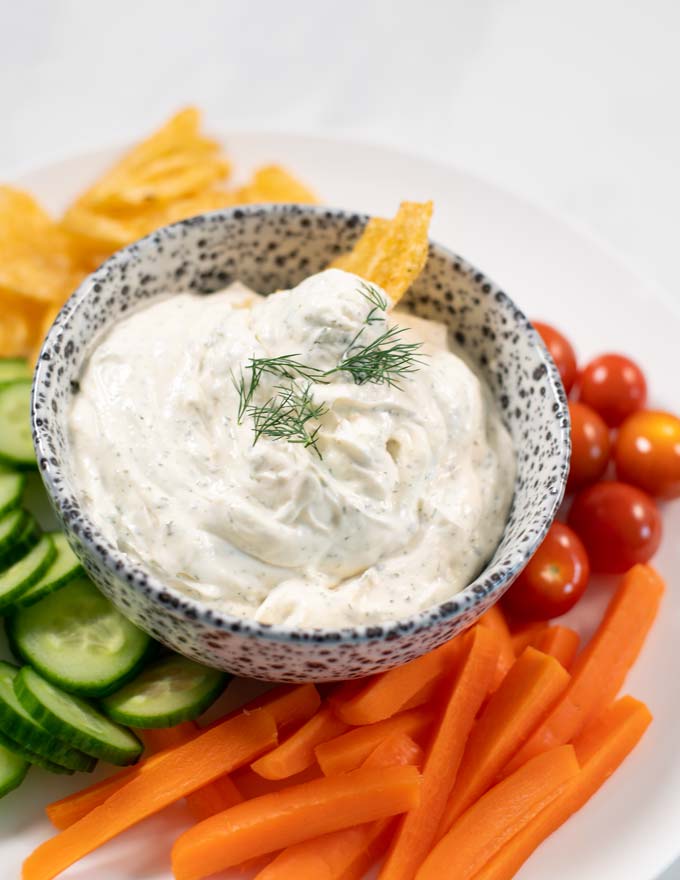View of Dill Dip served with carrots, tomatoes, and cucumbers.