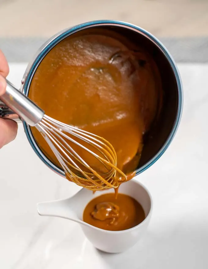 Carolina BBQ Sauce is poured from the saucepan into a serving bowl.