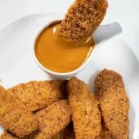 Dipping chicken tenders into Carolina BBQ Sauce.