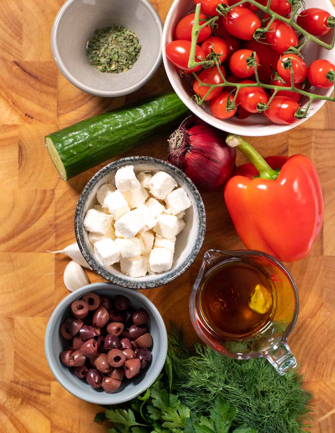 Ingredients needed for making Greek Salad are collected on a board. 