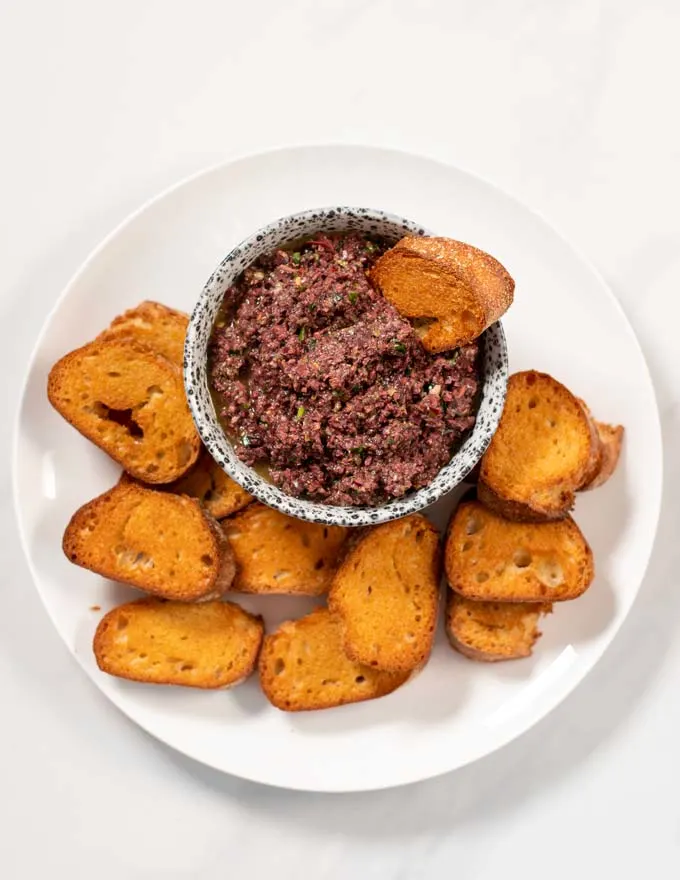 Bread is dipped into Olive Tapenade.