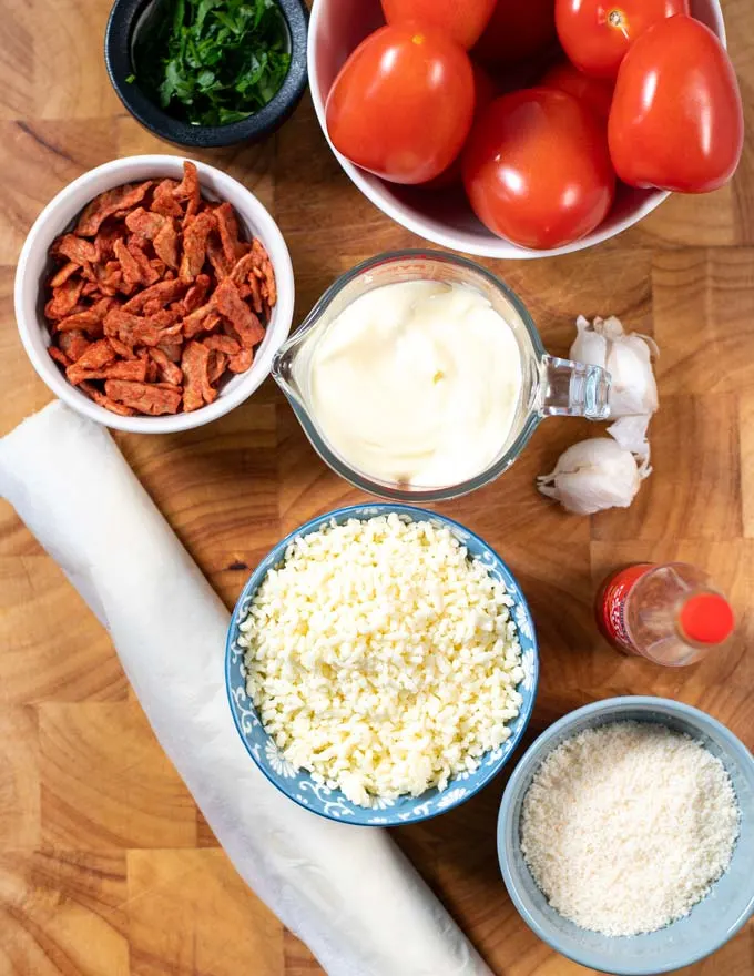 Ingredients needed to make Tomato Pie are collected on a board.