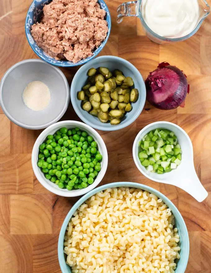 Ingredients needed for making Tuna Macaroni Salad on a board.