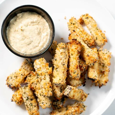 Eggplant Fries are served on a plate with dipping sauce.