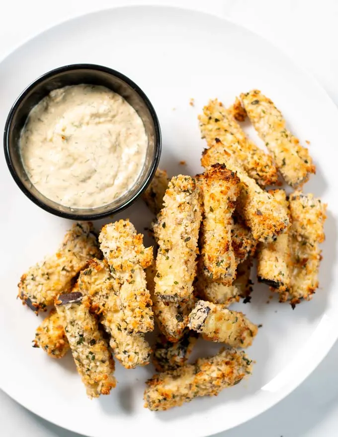 Eggplant Fries are served on a plate with dipping sauce.