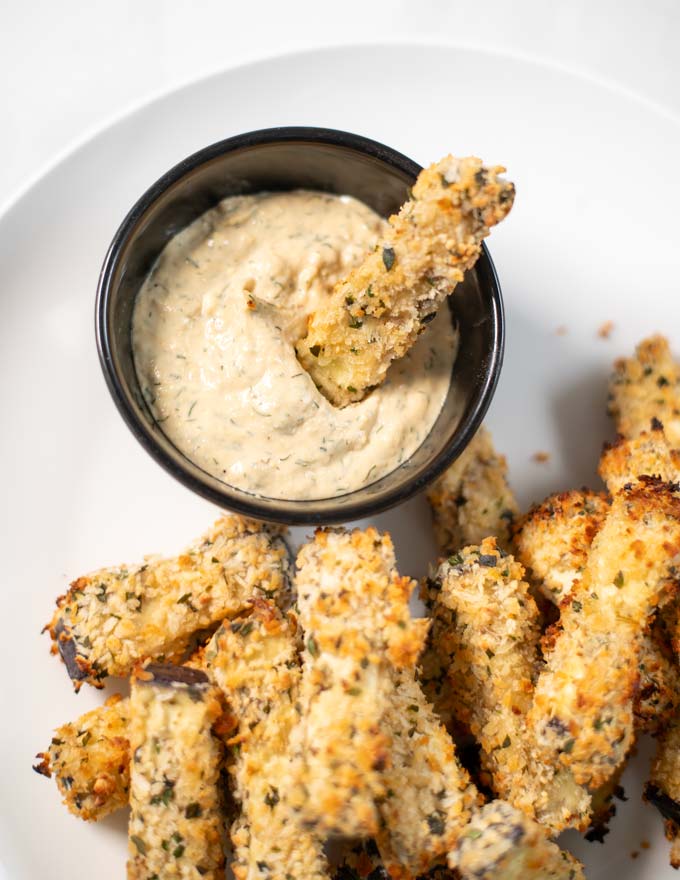 Eggplant Fries are dipped into sauce.